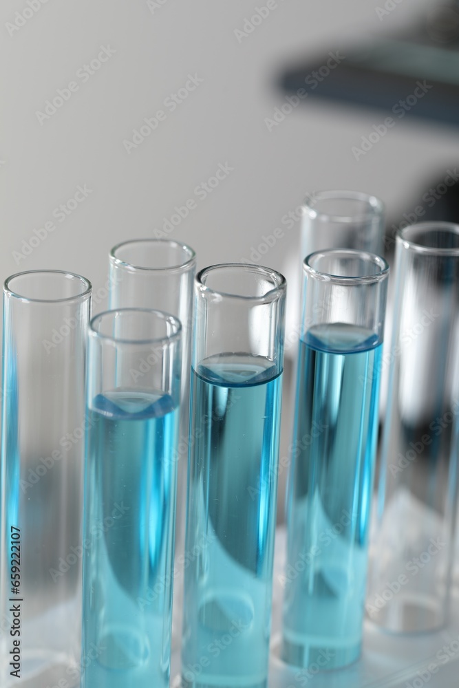 Test tubes with light blue liquid in laboratory, closeup Test tubes with light blue liquid in laboratory, closeup