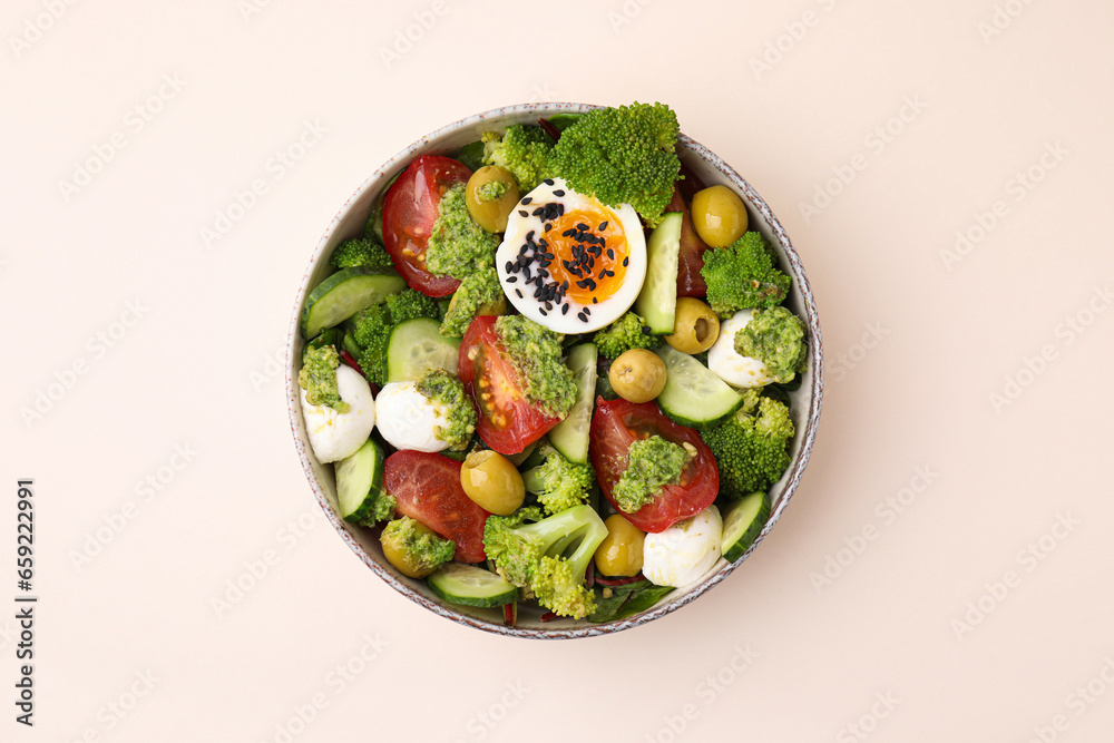 Delicious salad with pesto sauce in bowl on beige table, top view Delicious salad with pesto sauce in bowl on beige table, top view