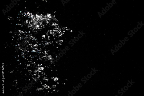 Many air bubbles in water on black background, space for text