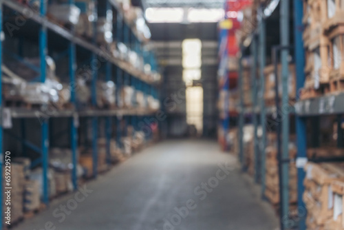 Blurred Background Commercial packaging on steel rack. Aisle in storehouse inventory. Warehouse background storage inventory shelf with freight container aisle space. Blur supply lot shelf cardboard