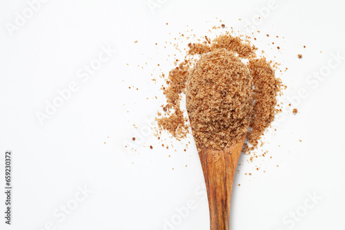 Brown sugar powder with wooden spoon on white background, Top view.