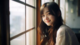 明るい窓辺で微笑む10代～20代の日本人女性のポートレート