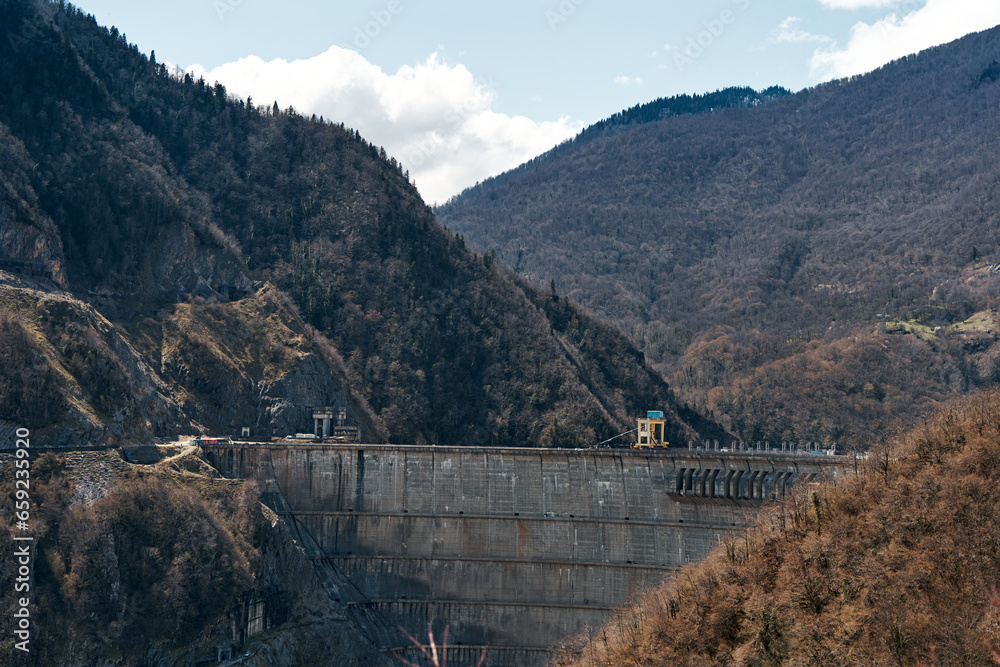 The dam of the Inguri hydroelectric power plant in the Sakartvelo mountains. A natural mountain landscape with energetic infrastructure