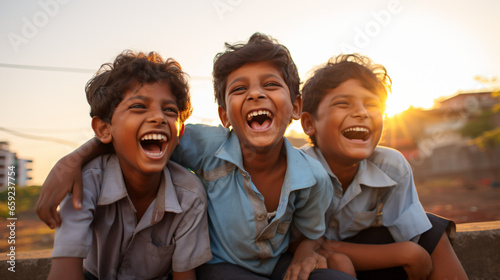 夕焼けの街の中で、アジア人の男の子3人が笑っている逆光の写真
