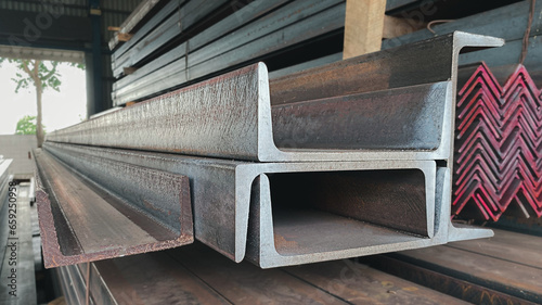 The steel channels are tied up in the warehouse before shipping. Construction steel is shaped like the letter U. photo