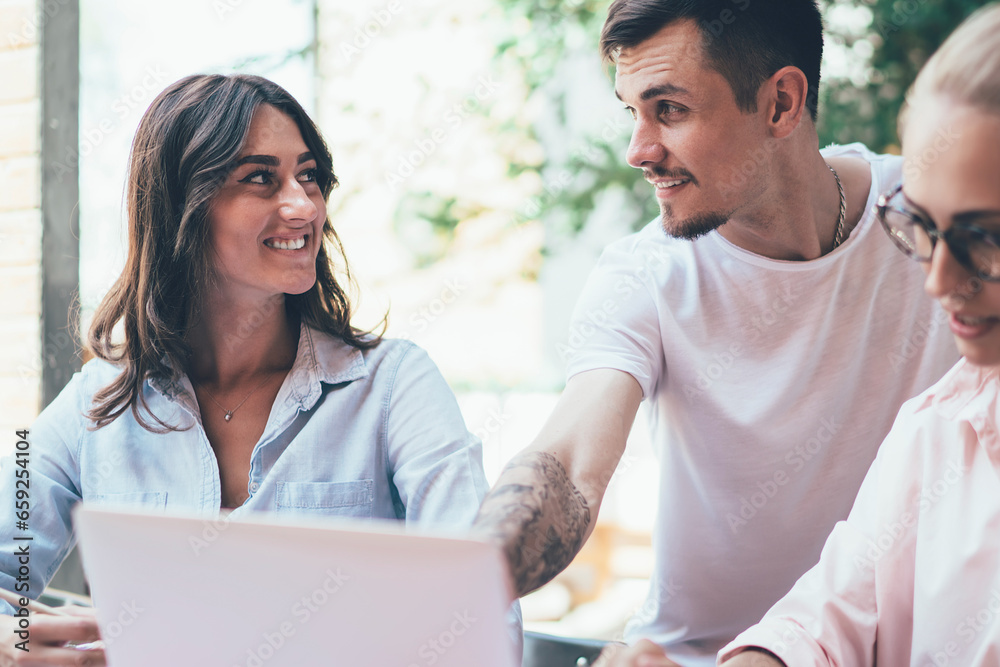 Business partners using gadgets in work and talking to each other Business partners using gadgets in work and talking to each other