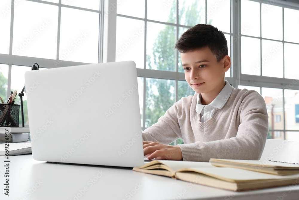 Little boy studying online with laptop at home Little boy studying online with laptop at home