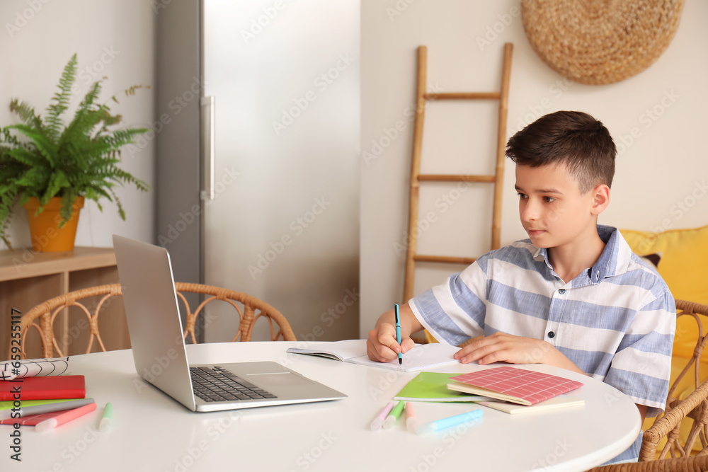 Little boy studying online with laptop at home Little boy studying online with laptop at home