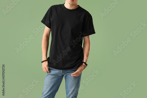 Man in stylish t-shirt on green background © Pixel-Shot