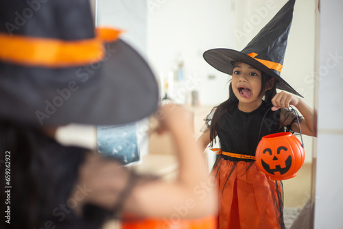 Happy Asian child girl in a witch costume to Halloween. trick or treat. Kids trick or treating.