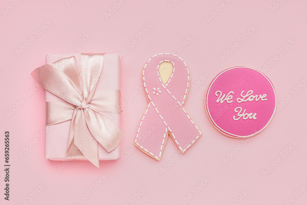 Gift box, cookies with ribbon and text WE LOVE YOU on pink background. Breast cancer awareness concept
