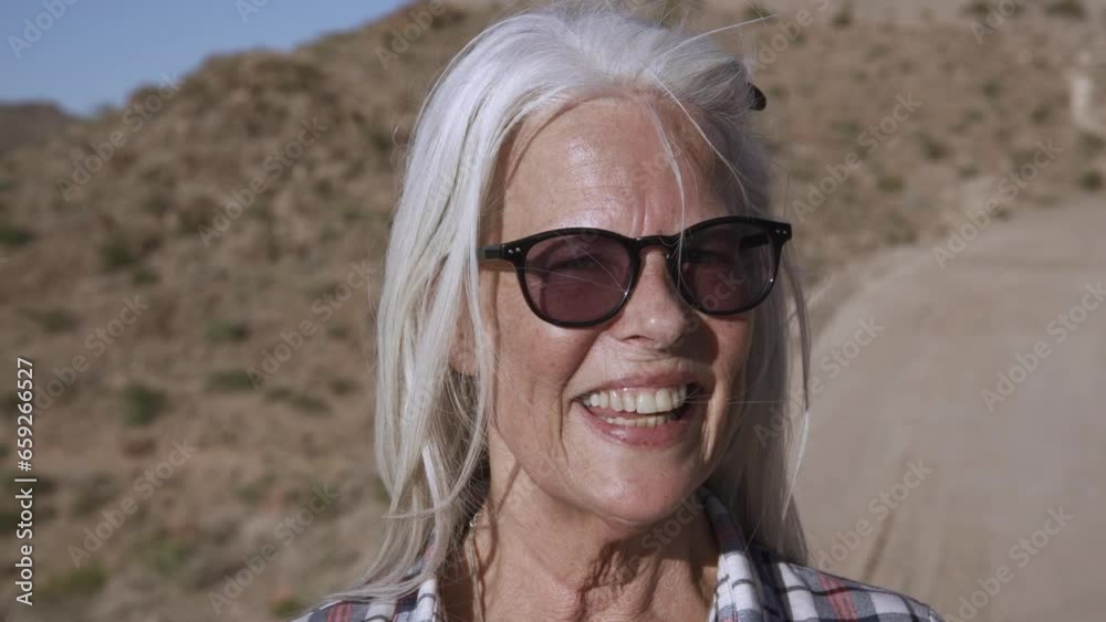 Portrait blond woman with sunglasses is smiling. She is happy and rest in deserts. Portrait blond woman with sunglasses is smiling. She is happy and rest in deserts.