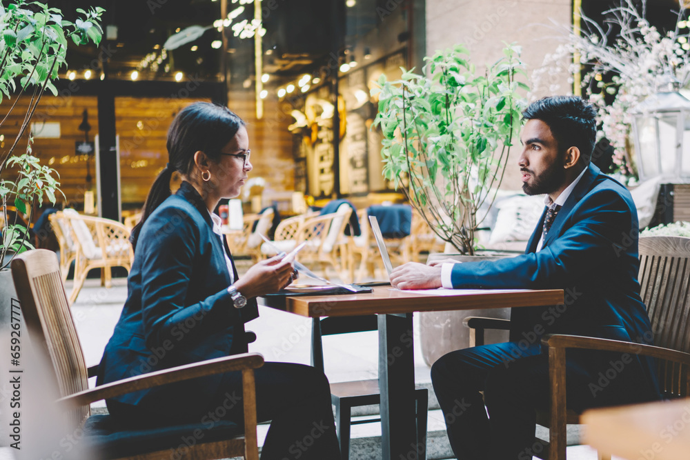 Business people chatting with each other in cafe Business people chatting with each other in cafe