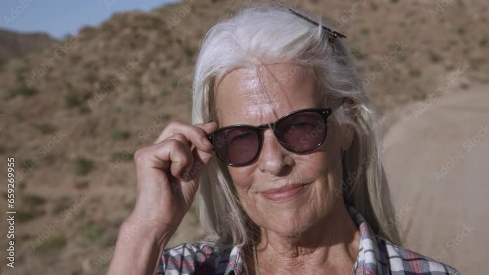 Portrait blond woman with sunglasses is smiling. She is happy and rest in deserts. Portrait blond woman with sunglasses is smiling. She is happy and rest in deserts.