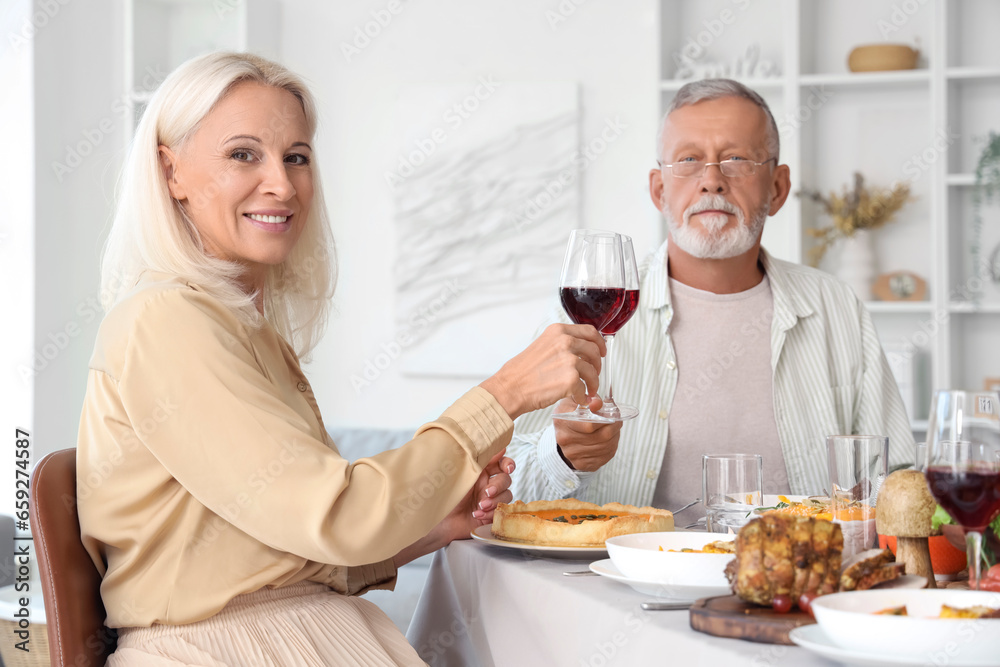 Mature couple having dinner at festive table on Thanksgiving Day Mature couple having dinner at festive table on Thanksgiving Day