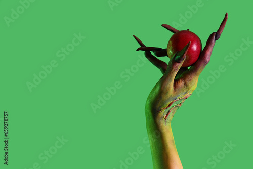Obraz na plátne Witch with apple on green background. Halloween celebration