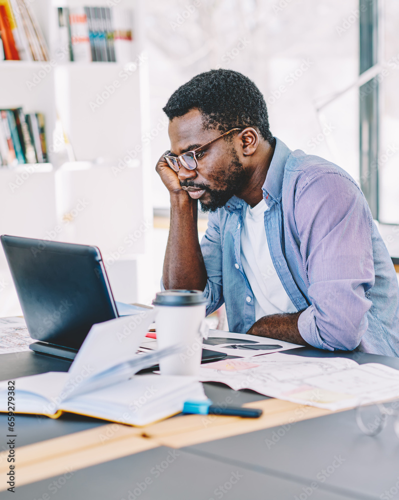 Black man working with laptop in office Black man working with laptop in office