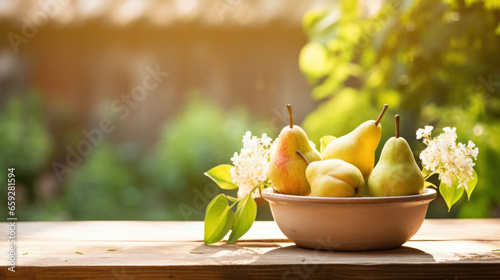 Pears in a ceramic bowl on a wooden table drenched in sunshine against a blurred garden backdrop