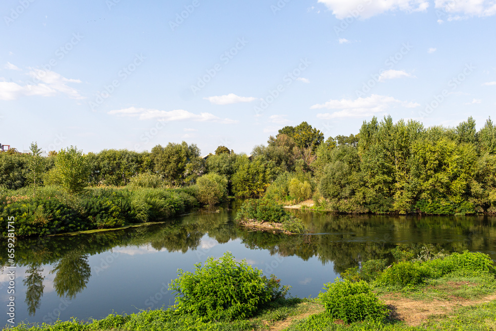 Landscape with river, trees and blue sky