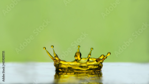 Water drop. Water drop crown blur. Slightly blurred golden yellow  water droplets. natural water drop concept and green background.