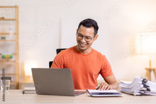 Happy business man work on laptop for email update, online project and reading digital report with mockup space. freelance asian man  entrepreneur and working from home research, planning and info 