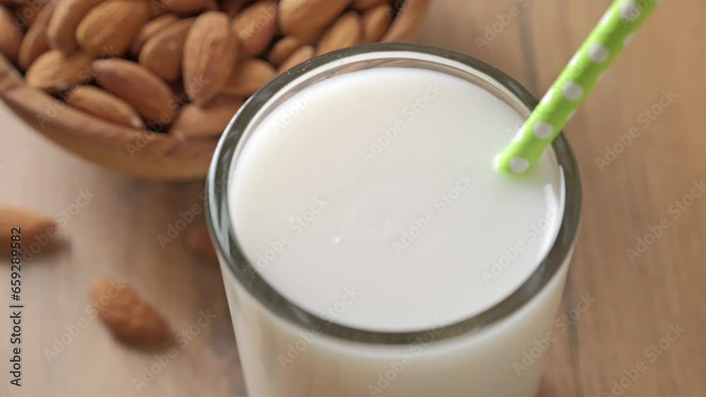 Fresh organic almond milk and almonds in a wooden bowl. Healthy food concept. Fresh organic almond milk and almonds in a wooden bowl. Healthy food concept.