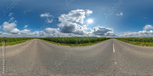 spherical 360 hdri panorama on old asphalt road among corn fields with clouds and sun on blue sky in equirectangular seamless projection  as skydome replacement in drone panoramas  game development