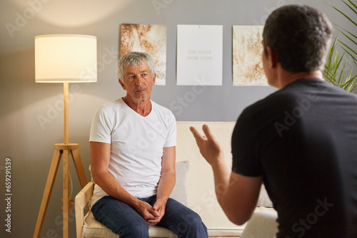 Senior man white T-shirt talking to psychologist at mental health, mature male talking with his son posing backwards about home problems family conflict.