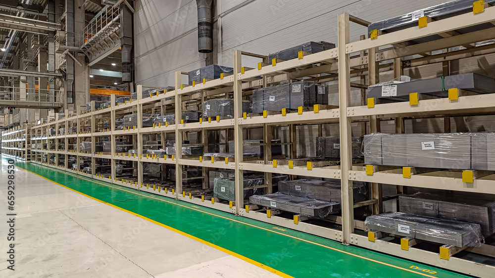 Racks with stored steel sheets for the production of automotive body parts in a factory Racks with stored steel sheets for the production of automotive body parts in a factory