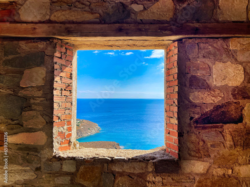 Open Framed Window in a wall of stone and brick in a construction site with an idyllic view of the Mediterranean Sea.  Stock Image.
