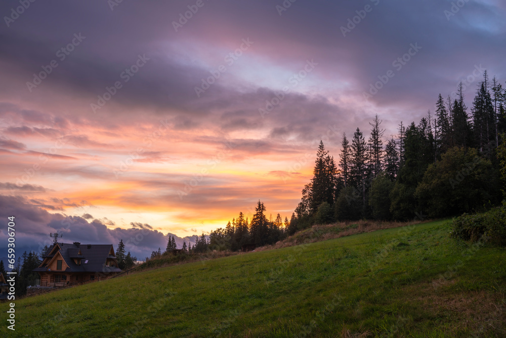 beautiful dramatic coloured sky over a meadow in the mountains.