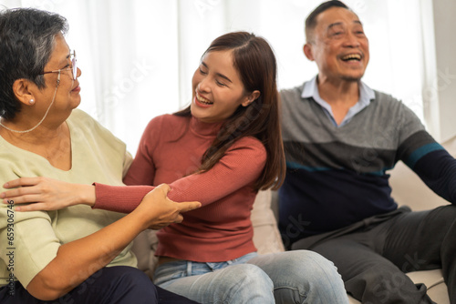 Fototapeta Naklejka Na Ścianę i Meble -  Portrait enjoy happy smiling love asian family.Senior mature father hug with elderly mother and young adult woman play laughing and having fun together at home.insurance concept