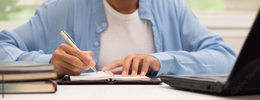 person writing on notebook while working at workplace in office, business learning concept person writing on notebook while working at workplace in office, business learning concept