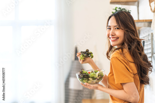 Fotografie Portrait of beauty body slim healthy asian woman eating vegan food healthy with fresh vegetable salad in kitchen at home
