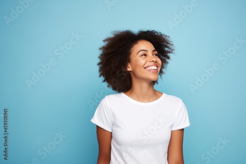 Portrait of a black woman with white clear t shirt isolated in blue studio.