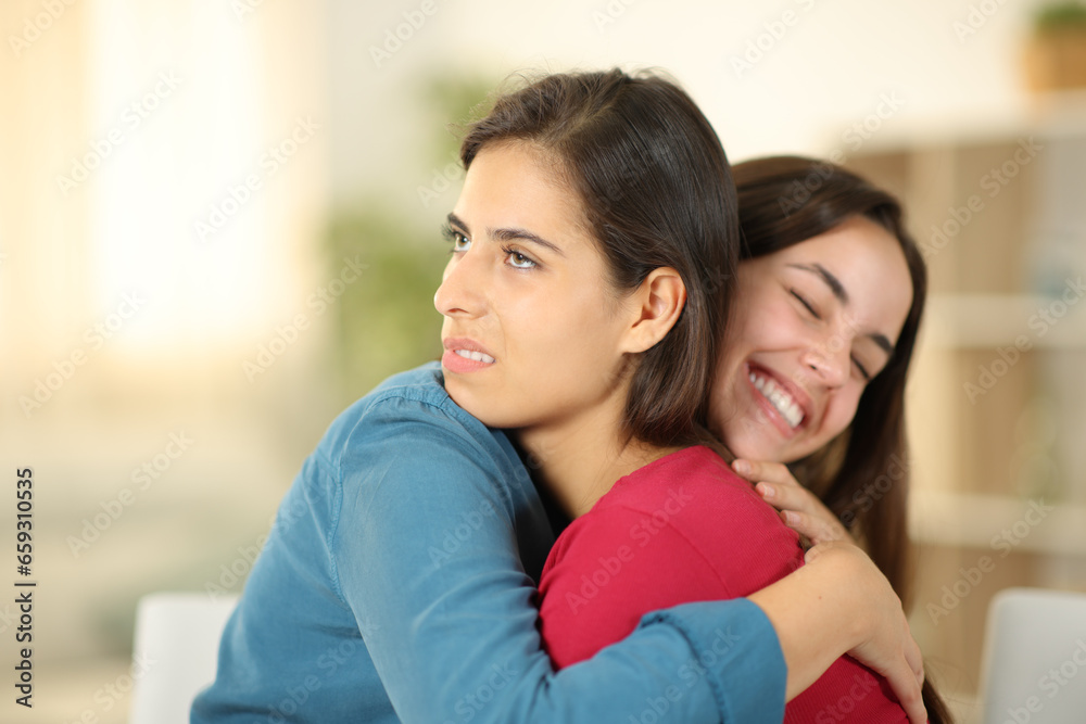 Happy woman hugging a false friend at home - obrazy, fototapety, plakaty 