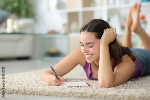 Happy woman taking notes in agenda at home