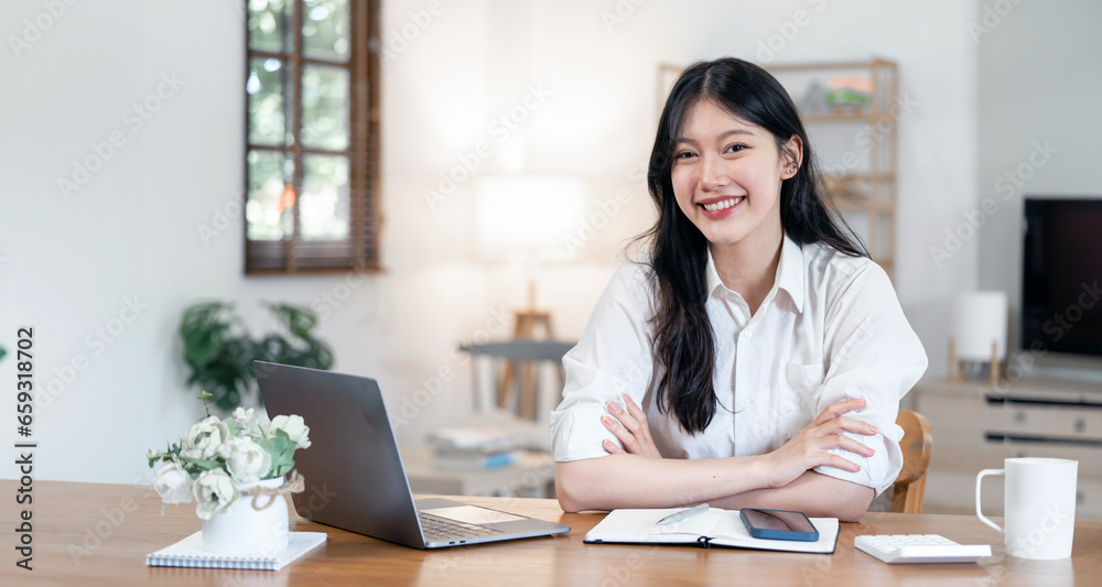 Young beautiful joyful woman smiling while working with laptop in office Young beautiful joyful woman smiling while working with laptop in office