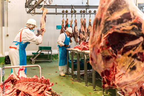 Slaughterhouse butchers cutting cow meat in cold storage