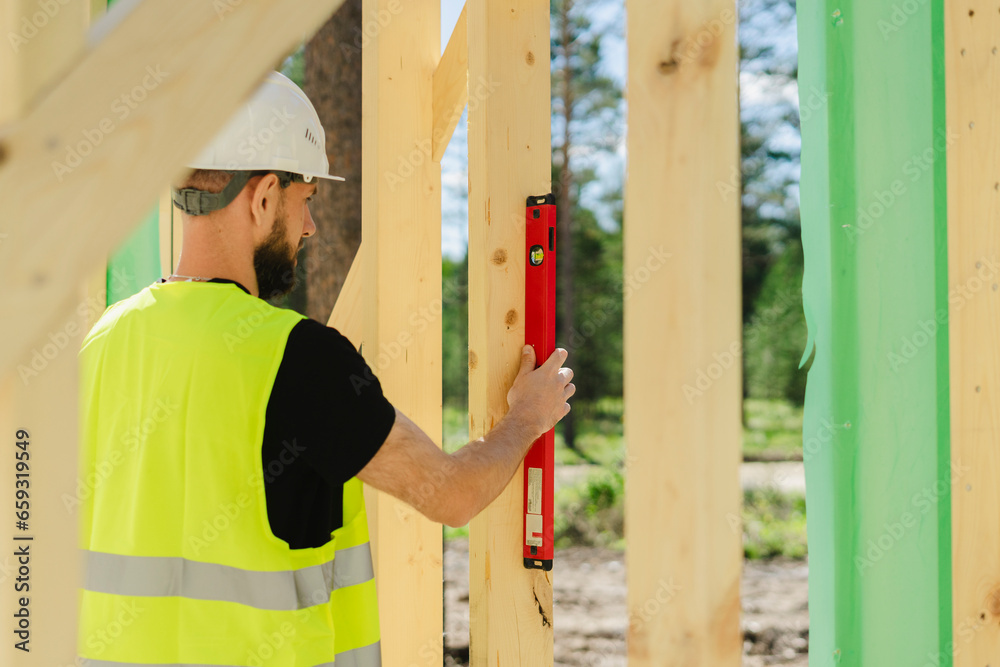 Engineer measuring wood with level tool at site Engineer measuring wood with level tool at site