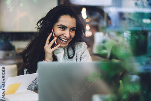 Young lady speaking on cellphone in cafe