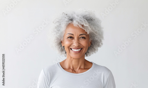 Portrait of smiling proud handsome african american senior woman standing against isolated white background. Wearing a white t-shirt copy space for advertisement or logo