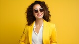 Selbstsichere Businessfrau im gelben Blazer lächelt selbstbewusst