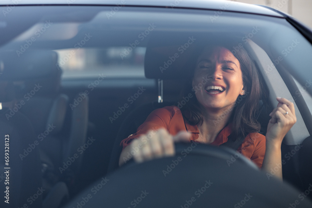 Photo of positive cheerful girl funky driver rider enjoy drive ride car under pop star hits playlist music try dance raise hands in city center - obrazy, fototapety, plakaty 