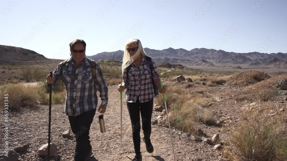 Two senior is hiking at rocks area during sunshine weather. Couple travelers research rock place in Nevada. Two senior is hiking at rocks area during sunshine weather. Couple travelers research rock place in Nevada.