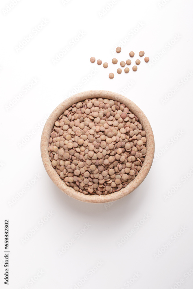 lentils in wooden bowl on white background shot from above lentils in wooden bowl on white background shot from above