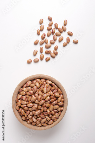 beans inside a wooden bowl on a white background shot from above
