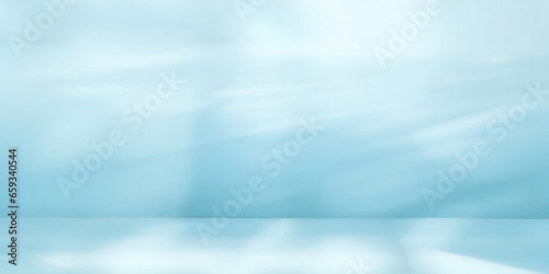 Minimalistic abstract gentle light blue background for product presentation with sunny light and intricate shadow on wall.