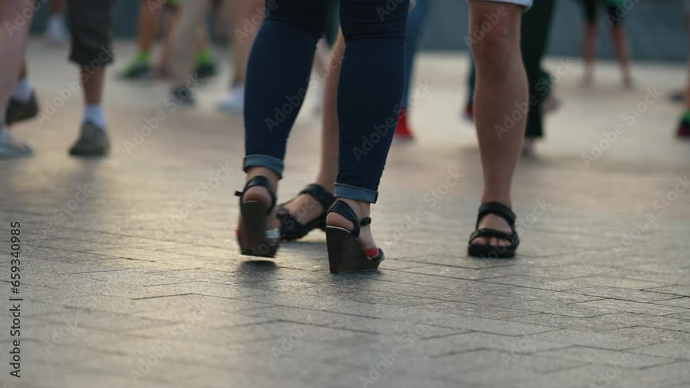 Closeup people's legs in summer clothing, dancing on an open terrace in the evening. People actively and joyfully spending their free time. Concept of active leisure Closeup people's legs in summer clothing, dancing on an open terrace in the evening. People actively and joyfully spending their free time. Concept of active leisure