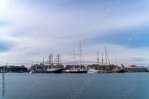 Long Exposure of Maritime Port with Sailing Ships and City Skyline at Dusk